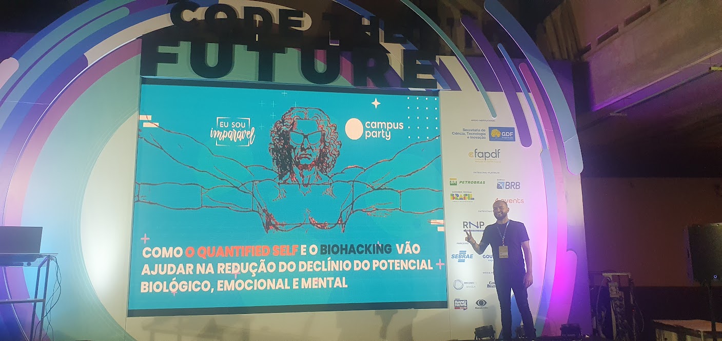 Tiago Pereiras no palco, em frente ao telão da palestra sobre Quantified Self e Biohacking